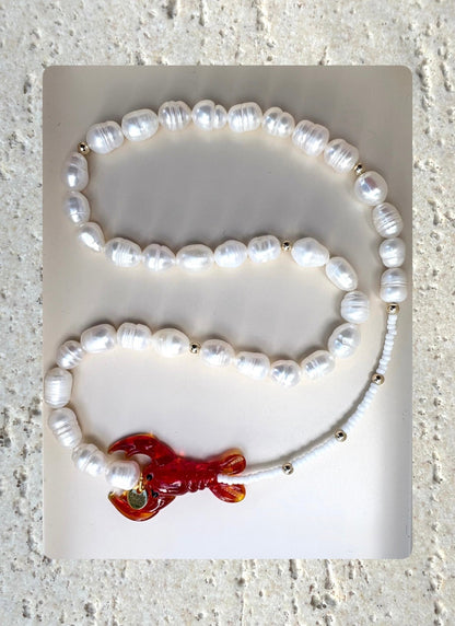 pearl necklace with a red lobster charm.