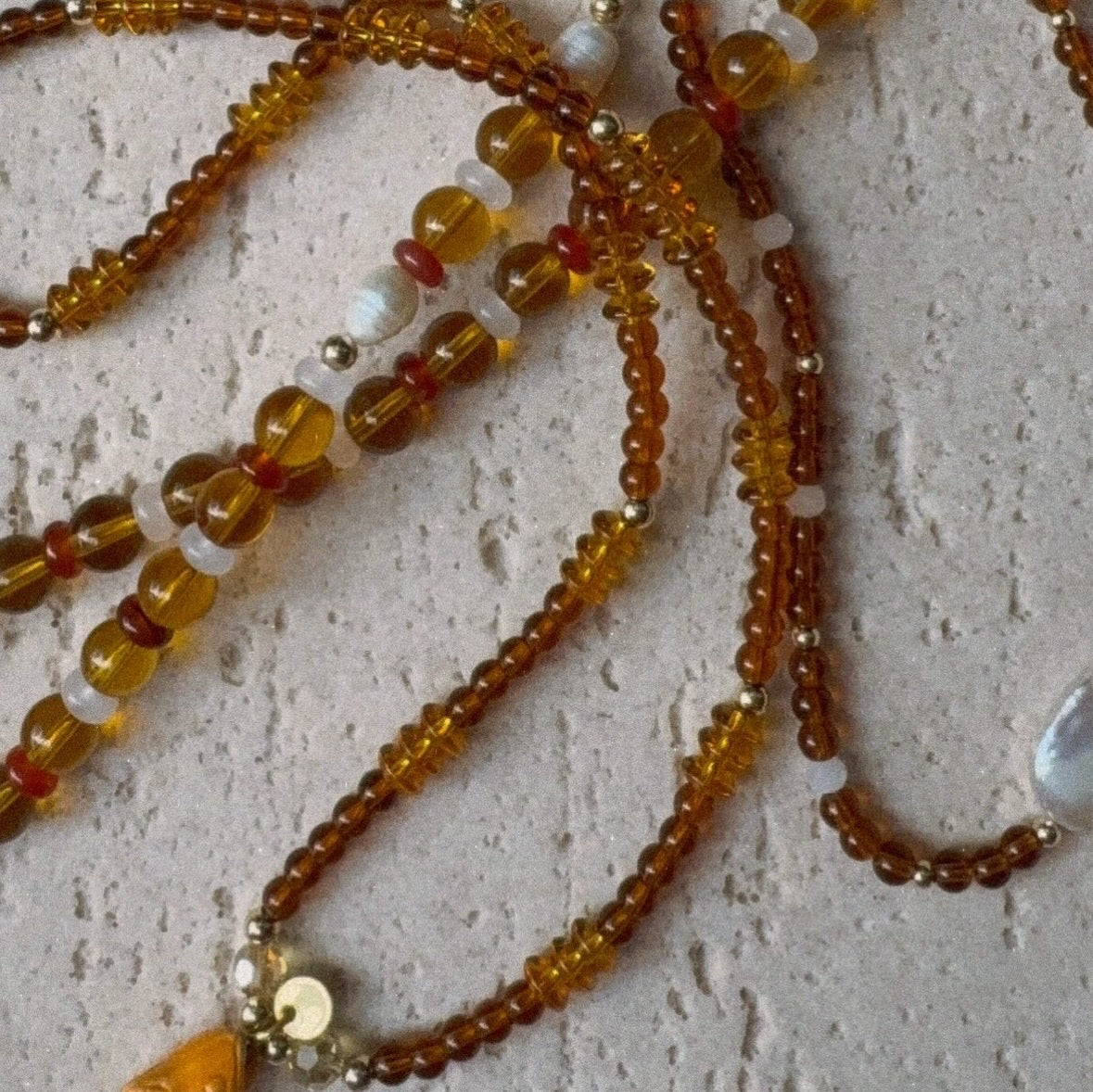 Browns and gold glass beaded necklace with repurposed orange fish charm