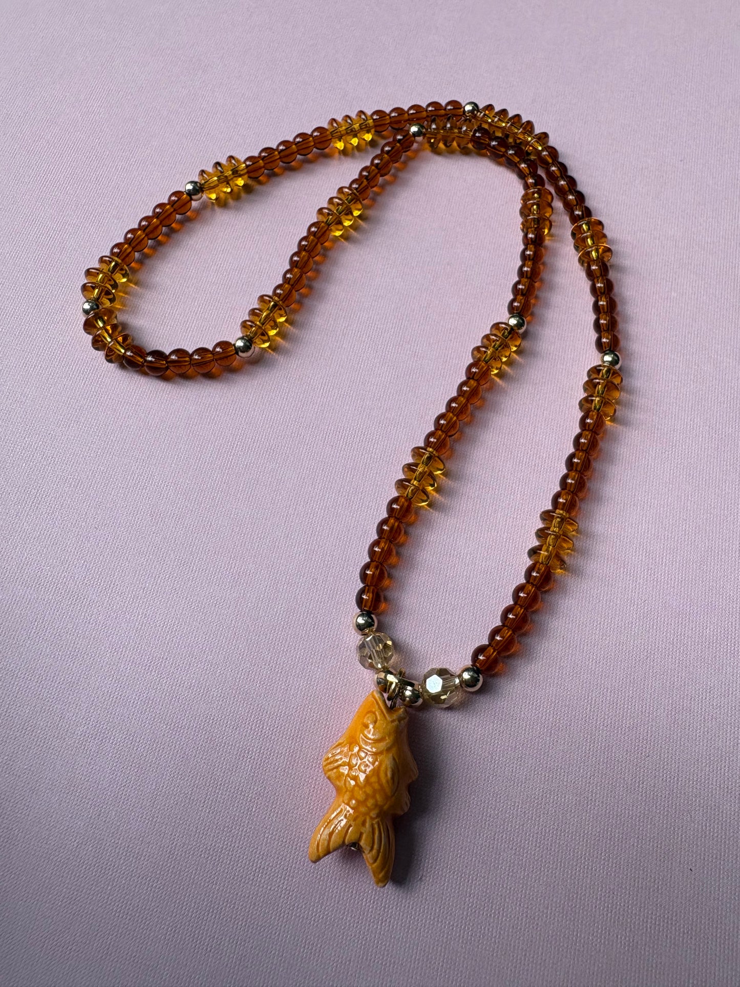 Browns and gold glass beaded necklace with repurposed orange fish charm