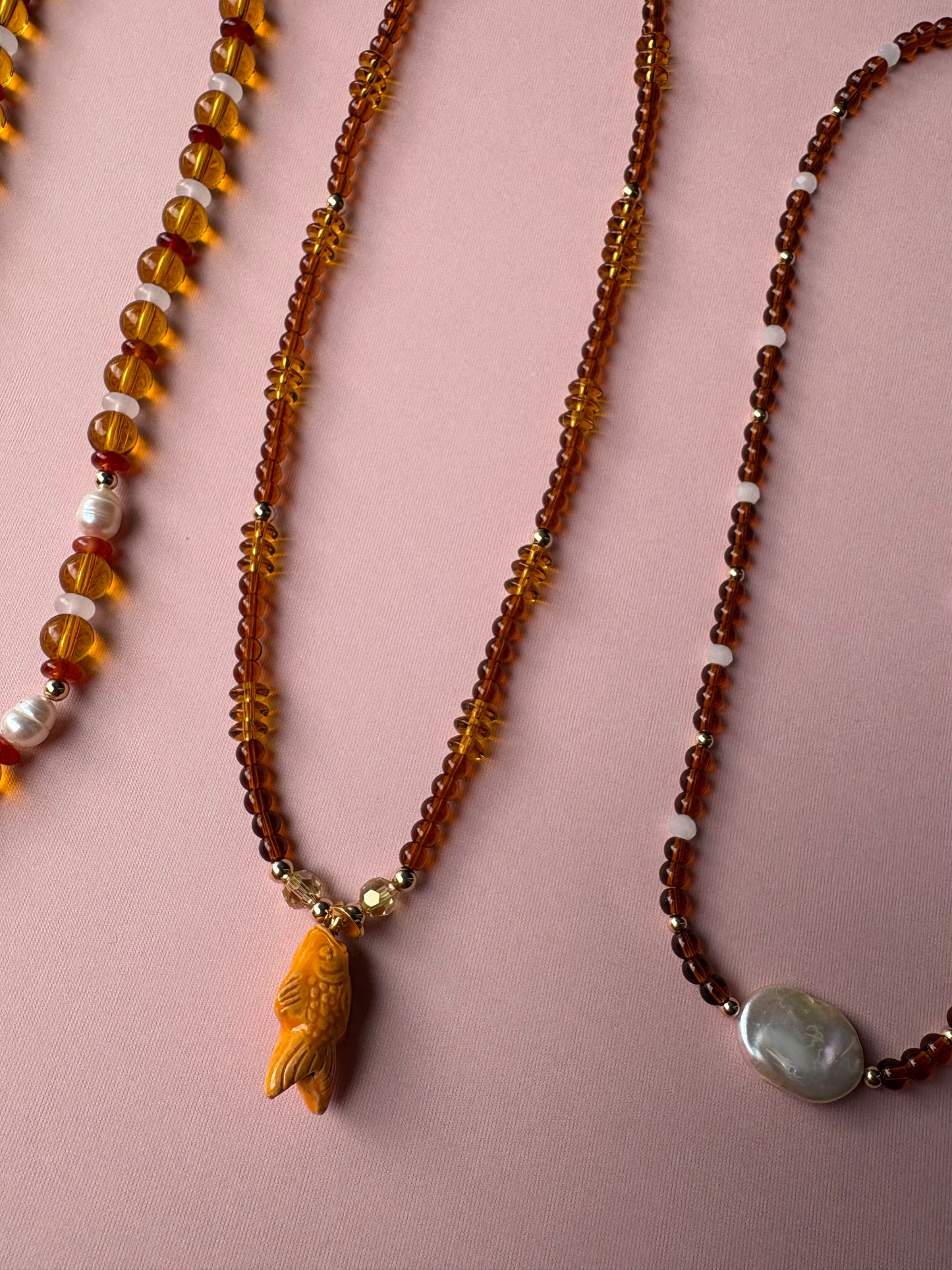 Browns and gold glass beaded necklace with repurposed orange fish charm