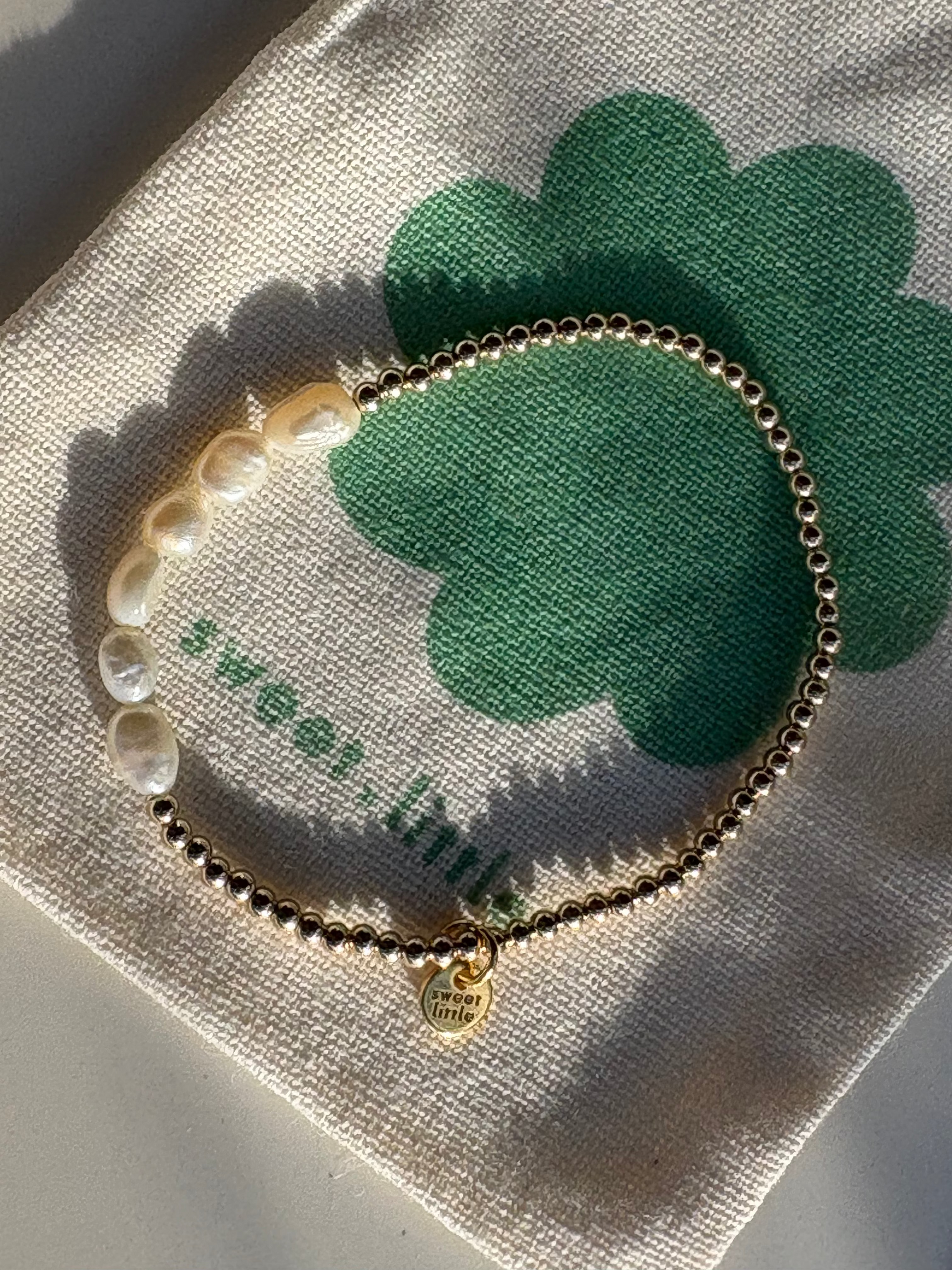 Bracelet with pearls on a cloth with a shamrock design